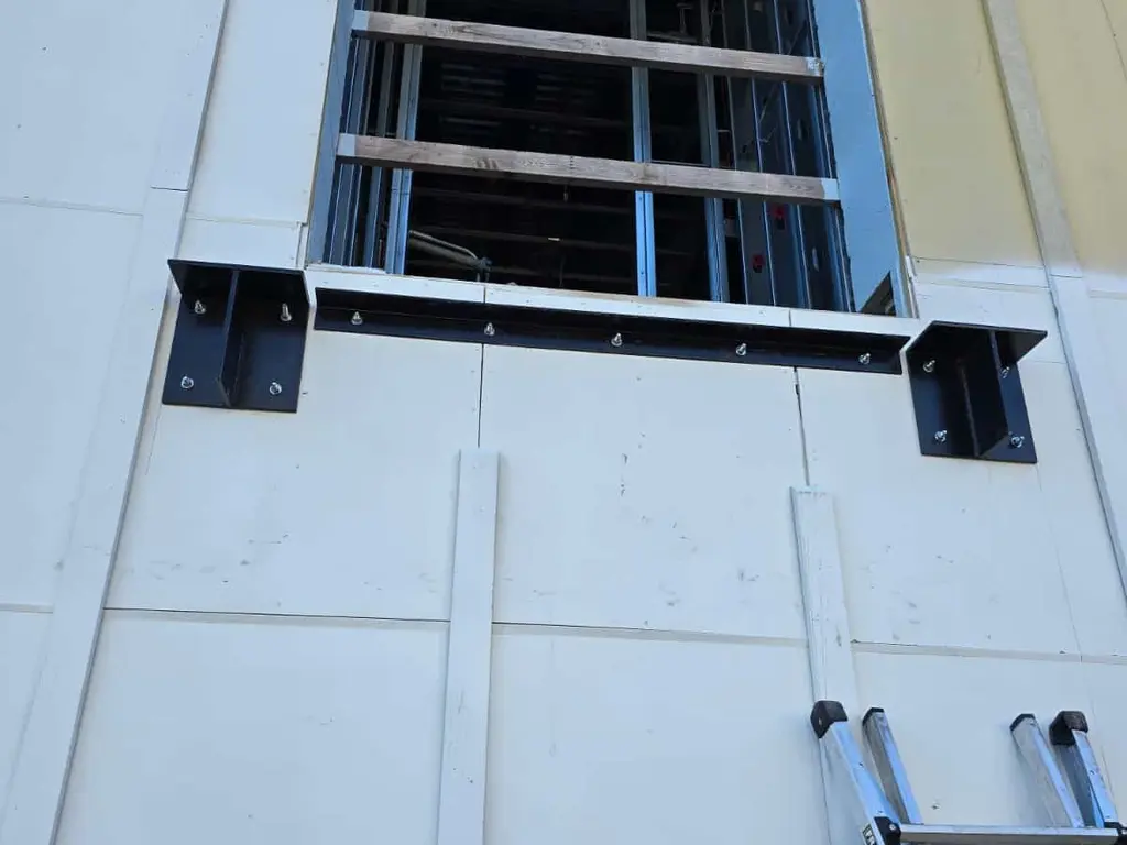 Soportes de acero y placas base anclados al muro